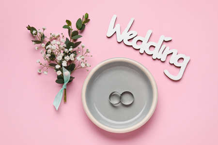 Beautiful composition with wedding rings on color backgroundの写真素材