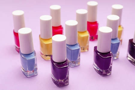 Set of nail polish bottles on color background