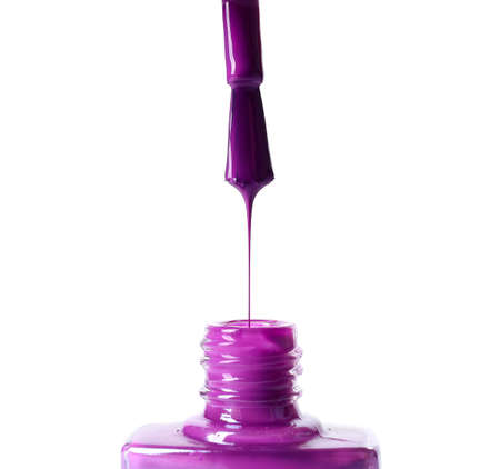 Nail polish dripping from brush on white backgroundの写真素材