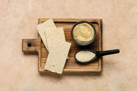 Bowl with tasty baba ghanoush, crackers and sesame on color backgroundの写真素材