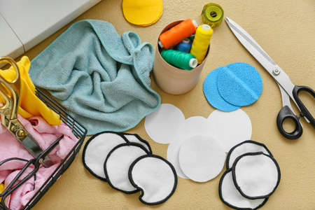 Materials for making reusable cotton pads on beige background