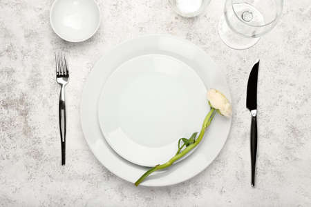Stylish table setting and ranunculus flower on light background