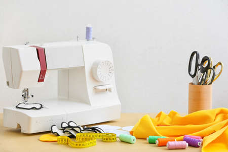 Materials for making reusable cotton pads and sewing machine on table against white background