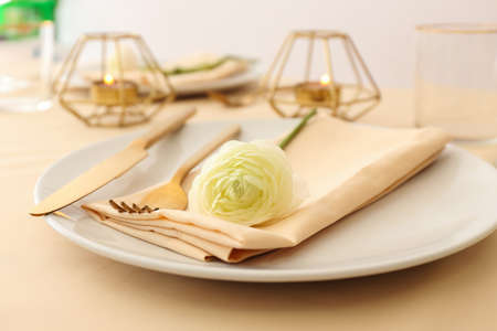 Stylish table setting and ranunculus flower on color backgroundの写真素材