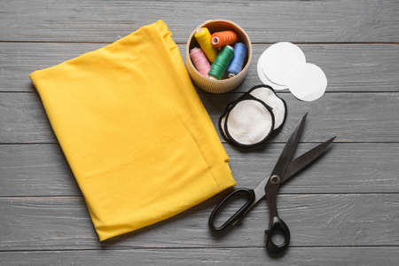 Handmade cotton pads with materials on dark wooden background