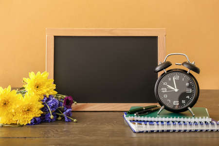 Flowers, stationery and blackboard on color background. teacher's day celebration