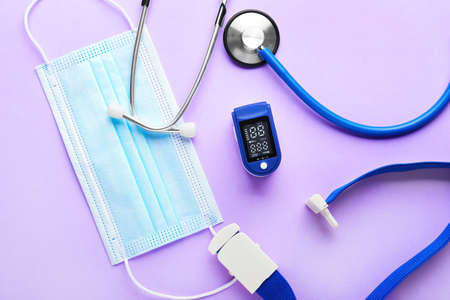 Composition with pulse oximeter and medical mask on color backgroundの写真素材