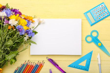 Blank sheet of paper, wild flowers and stationery on color wooden backgroundの写真素材