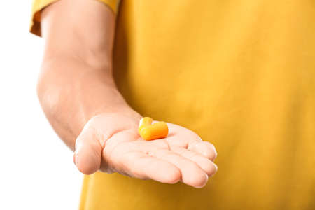 Young man with yellow earplugs on white backgroundの写真素材