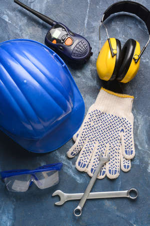 Safety equipment with builder's tools and radio transmitter on color backgroundの写真素材