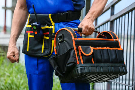 Male worker with tool bag and construction siteの写真素材