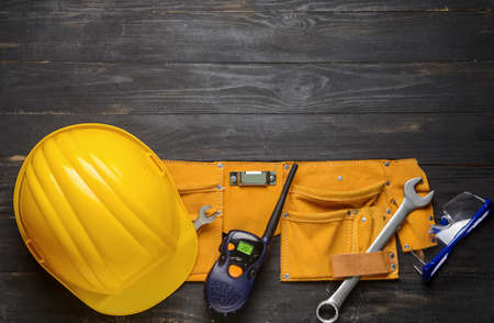 Safety equipment with radio transmitter and builder's tools on dark wooden backgroundの写真素材