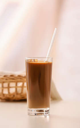 Glass of tasty iced coffee on table