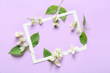 Composition with beautiful jasmine flowers and paper frame on color backgroundの写真素材