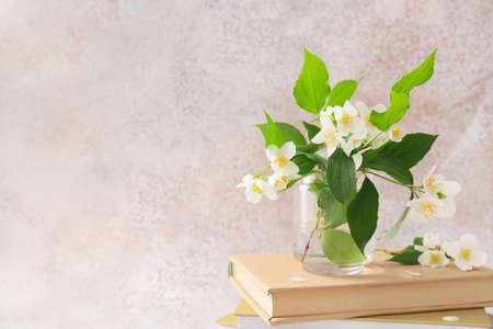 Composition with books and beautiful jasmine flowers on grunge background