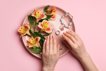 Hands with beautiful manicure, flowers and accessories on color backgroundの写真素材