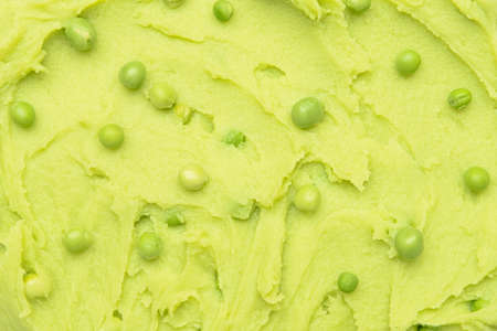 Tasty mashed potatoes and green peas as background, closeup