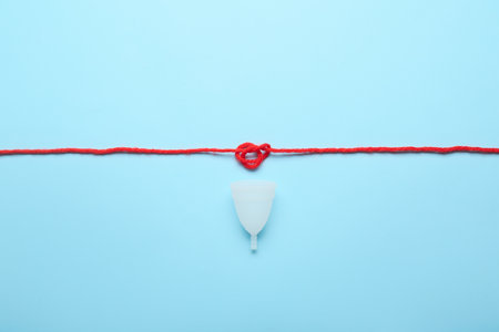 Menstrual cup and thread on color backgroundの写真素材