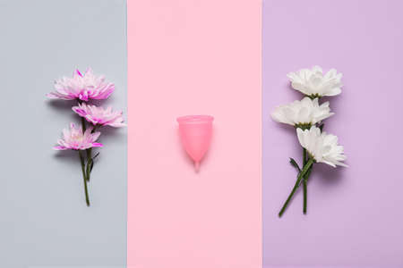 Menstrual cup and flowers on color backgroundの写真素材