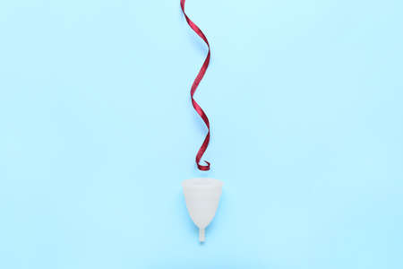Menstrual cup and ribbon on color backgroundの写真素材