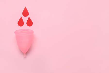 Composition with menstrual cup and blood drops on pink backgroundの写真素材