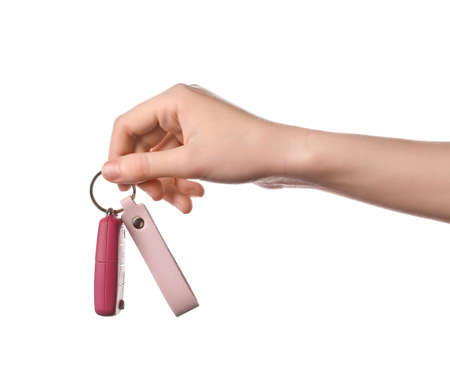Female hand with car key and leather keychain on white backgroundの写真素材