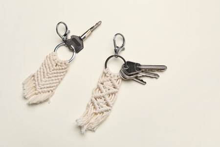 Keys with handmade cotton keychains on light background