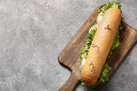 Board with tasty sandwich on grunge backgroundの写真素材