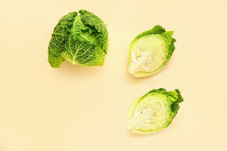 Pieces of fresh savoy cabbage on color background