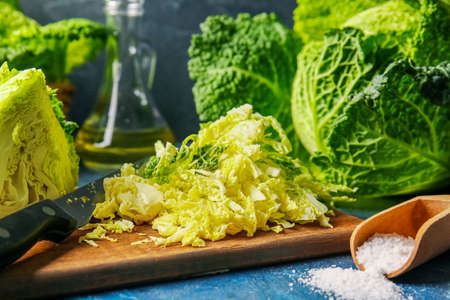 Board with heap of cut savoy cabbage on color background, closeupの写真素材