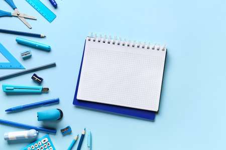 Blank notebook and stationery supplies on color backgroundの写真素材