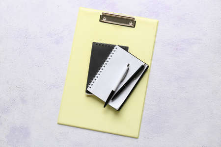 Blank notebook and stationery supplies on light background