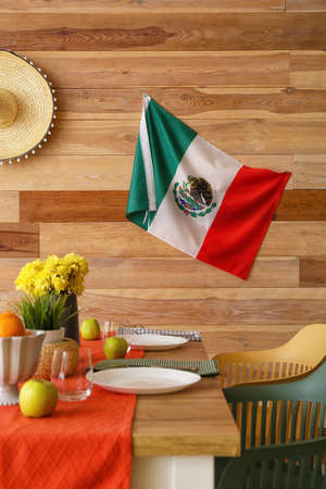 Mexican flag and dining table near wooden wallの写真素材