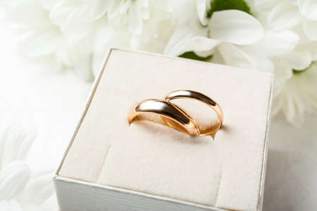 Box with wedding rings on light table, closeup