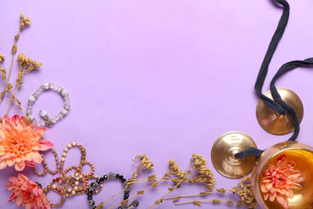 Tibetan singing bowl, karatalas, bracelets and flowers on color backgroundの写真素材