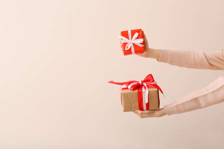 Hands with gifts on light background
