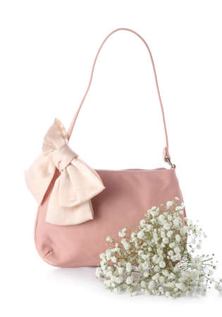 Stylish female handbag, hair bow and beautiful gypsophila flowers on white backgroundの写真素材