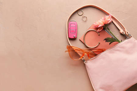 Stylish female bag with accessories and car key on color backgroundの写真素材