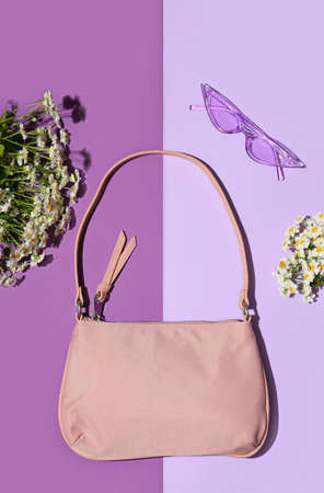 Stylish female accessories, sunglasses and beautiful flowers on color backgroundの写真素材