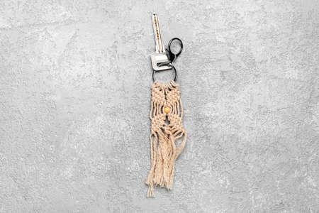 Key with handmade cotton keychain on gray background