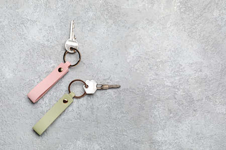 Keys with leather keychains on gray backgroundの写真素材