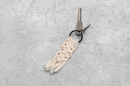 Key with handmade cotton keychain on gray background
