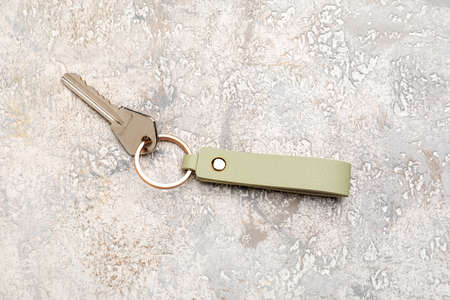 Key with leather keychain on light background