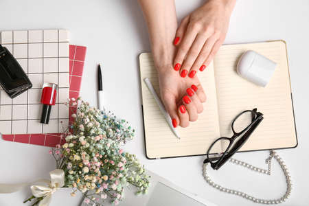 Woman with beautiful manicure, accessories, stationery and earphones on white backgroundの写真素材