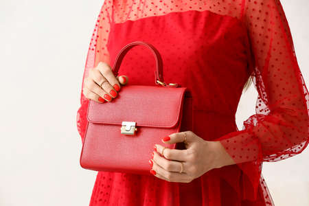 Fashionable woman with beautiful manicure holding stylish handbag on white background, closeupの写真素材