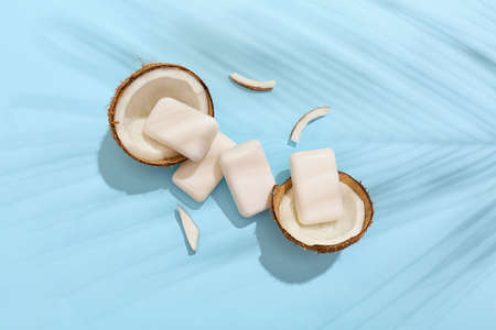Soap bars and coconut on color background