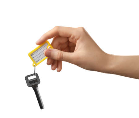 Woman holding key with plastic tag on white background
