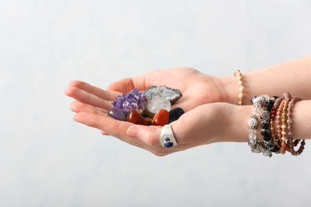 Female hands with beautiful gemstones on light backgroundの写真素材