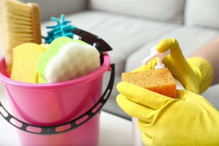 Young man with cleaning sponge and detergent at home, closeupの写真素材