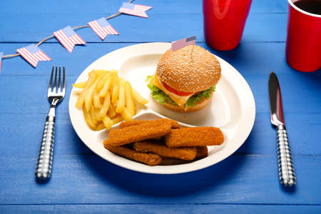 Plate with traditional American food on color wooden background